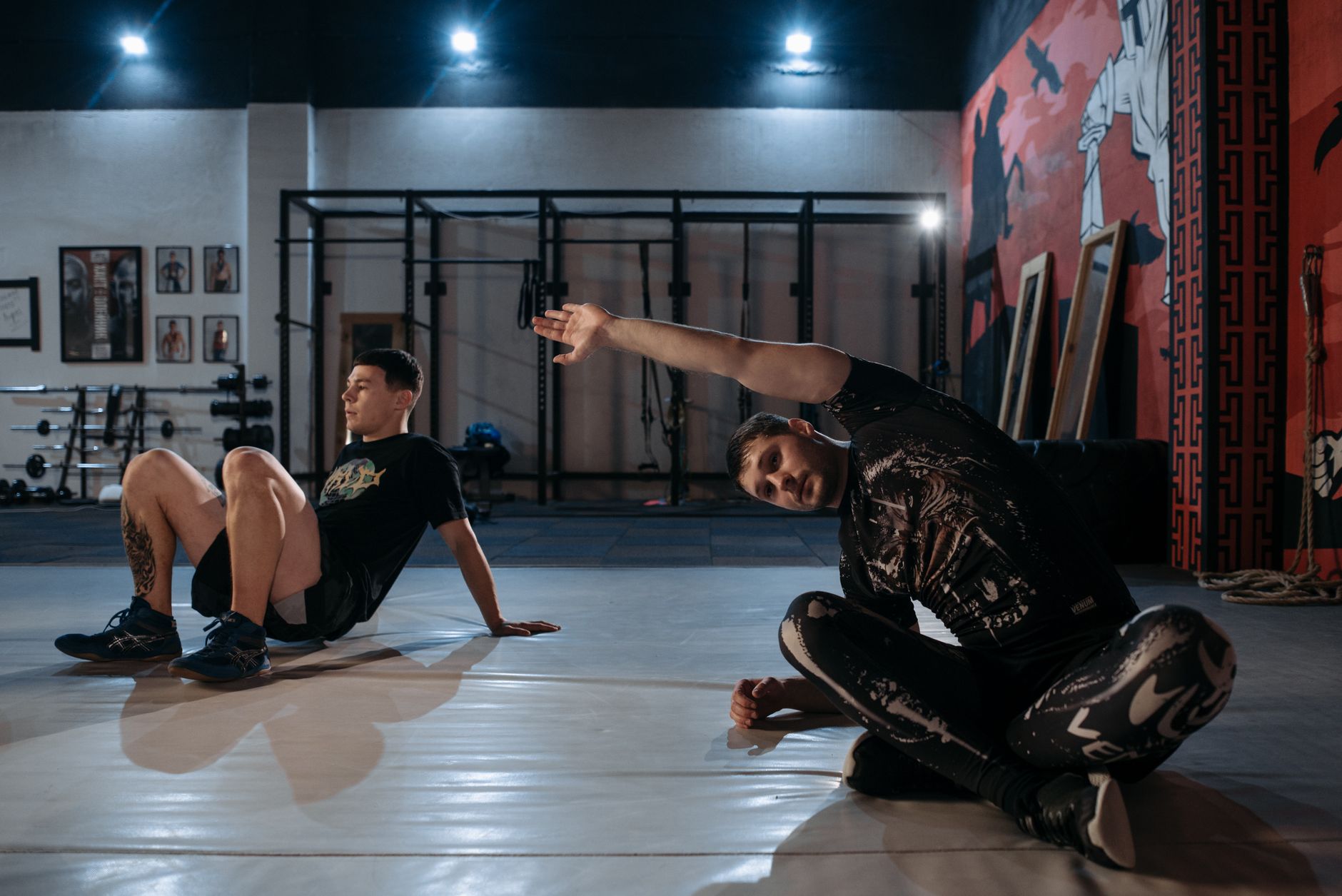 Two people in warm-up positions on a studio floor